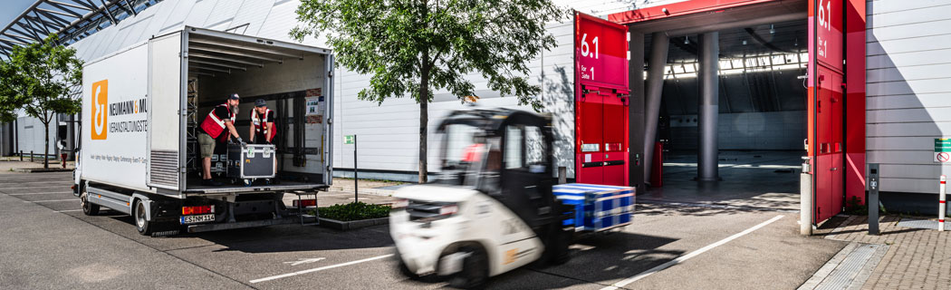 Zwei Männer entladen einen LKW vor der Halle 6